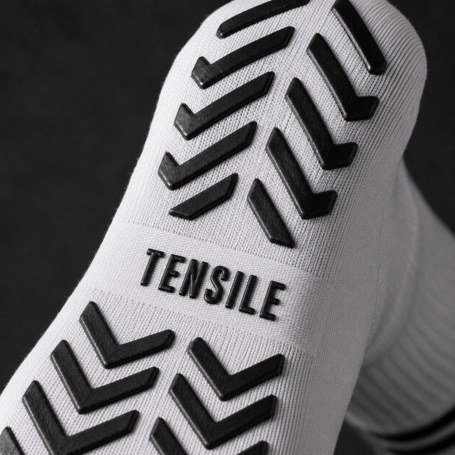 Makroaufnahme der TENSILE Silikon-Grip-Sohle mit Chevron-Muster und eingepr&auml;gtem Markenschriftzug